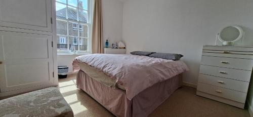 a bedroom with a bed and a dresser and a mirror at Sailor's Rest in Anstruther