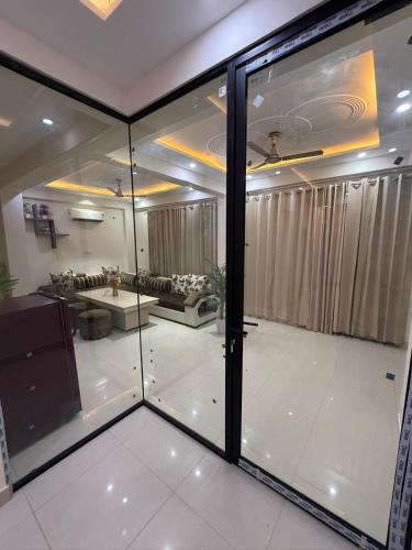 a view of a living room through a glass window at Cloud Bay Hotels - Sector 69 in Gurgaon