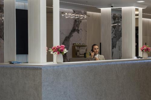 a man talking on a cell phone in front of a mirror at Hotel Condor in Mamaia