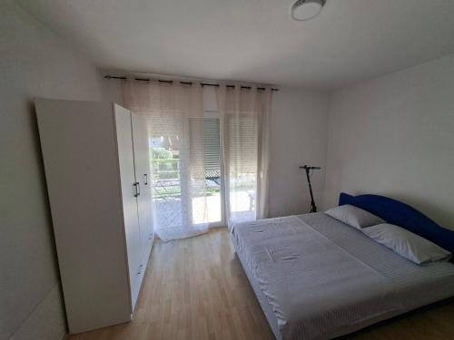 a bedroom with a bed and a large window at Apartman Leka in Donji Bogdašići