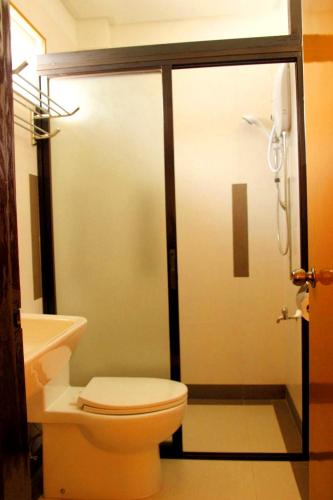 a bathroom with a shower with a toilet and a sink at Casa Belina in Puerto Princesa City