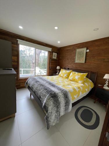 a bedroom with a large bed and a window at Cabañas Laguna Magica in Valdivia