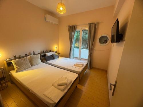 a bedroom with two beds and a window at Seaside Garden House 7 in Dassia