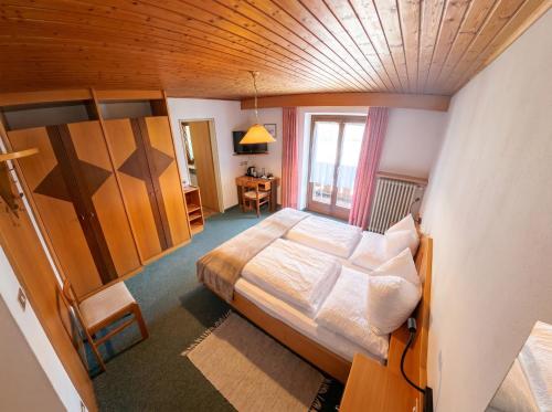 a bedroom with a bed and a wooden ceiling at Garni Renzler in Rasun di Sopra