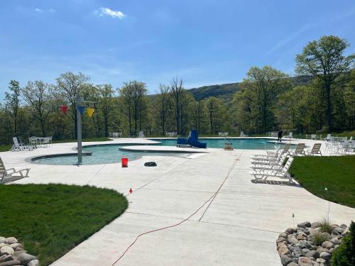 a swimming pool with chairs and a picnic table at House Juniper in Tannersville