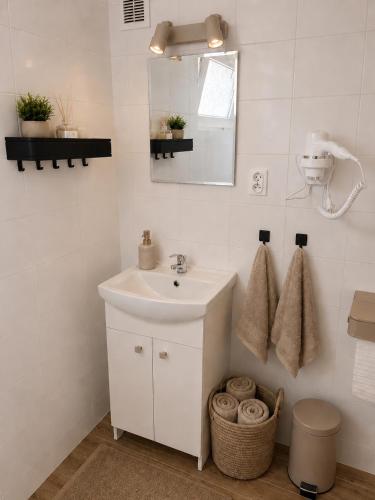a white bathroom with a sink and a mirror at Lake House Mierzyn in Mierzyn