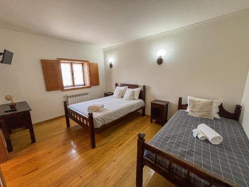 a bedroom with two beds and a window at Casa de Padreiro by Gerês Casas in Caniçada