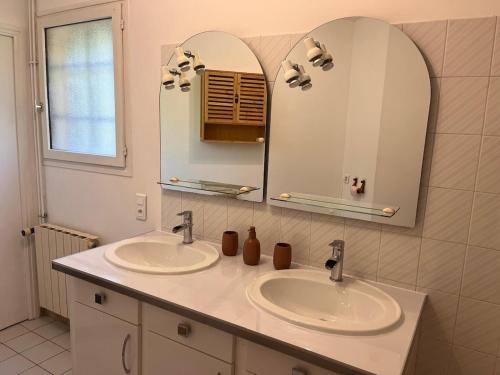 a bathroom with two sinks and a mirror at Le Gîte Martin in Quillan
