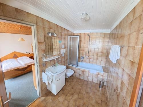 a bathroom with a sink and a toilet and a tub at Garni Renzler in Rasun di Sopra