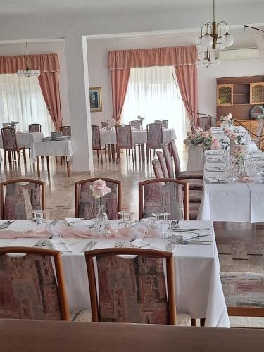 a dining room with white tables and chairs at Hotel Svizzero in Sangineto