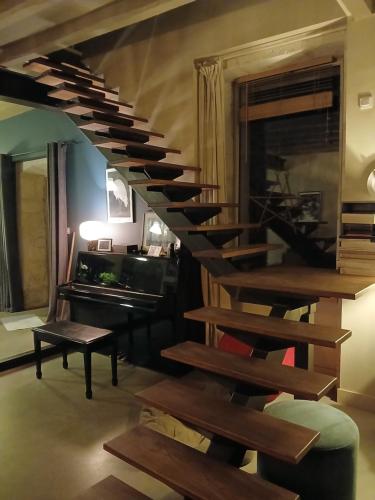 a wooden spiral staircase in a room with a piano at la chaume st martin in Angoulême
