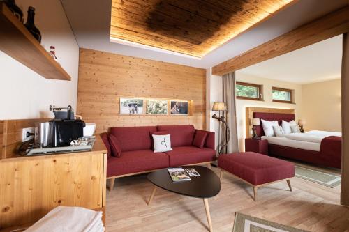 a living room with a red couch and a bed at Genussgut Krispel in Neusetz