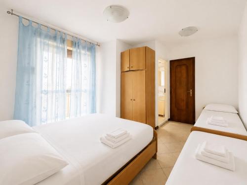 a bedroom with two beds and a window at Anthea - Timavo apartament 1 in Lignano Sabbiadoro