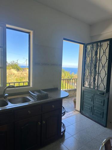 a kitchen with a sink and a view of the ocean at Casa 52 in Machico