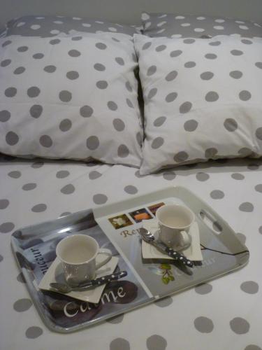 - un plateau avec 2 tasses et une assiette sur le lit dans l'établissement Le Cordeliers Presqu'ile, à Lyon