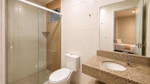 a bathroom with a toilet and a sink and a mirror at Van Gogh by OlaMar Bombinhas in Bombinhas