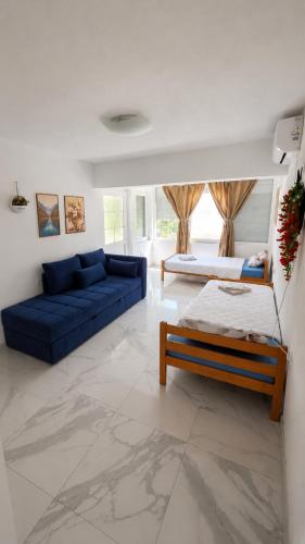 a living room with a blue couch and a bed at Villa Milla near Autopat e 75 in Veles