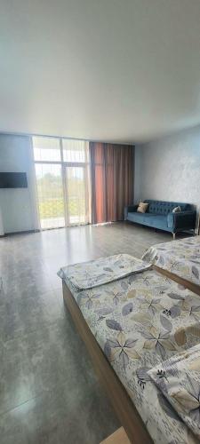 a room with two beds and a couch in it at Hotel Datuna Aurum in Kobuleti