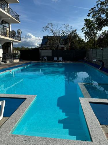 a large swimming pool with blue water at Hotel Datuna Aurum in Kobuleti