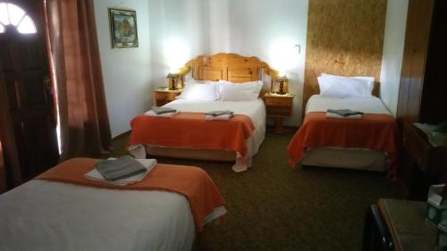 a hotel room with two beds with orange sheets at Afrique Guesthouse in Upington