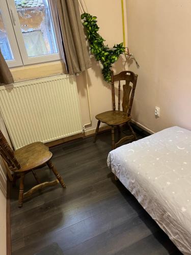 a bedroom with two chairs and a bed and a window at jack hostel with private bathroom in Sremski Karlovci