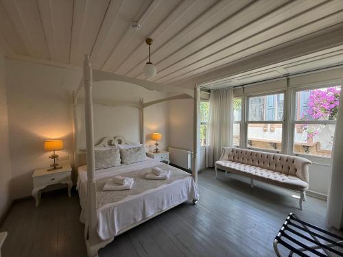 a bedroom with a bed and a couch and a window at Gule Cunda in Ayvalık