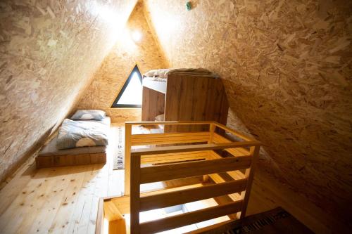 a attic room with a bunk bed and a ladder at Kraljičini konaci in Doboj