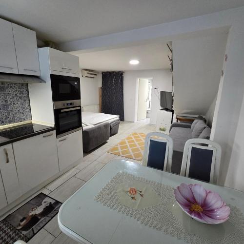 a kitchen and a living room with a table with a flower on it at Pri tetki 2 in Kranj