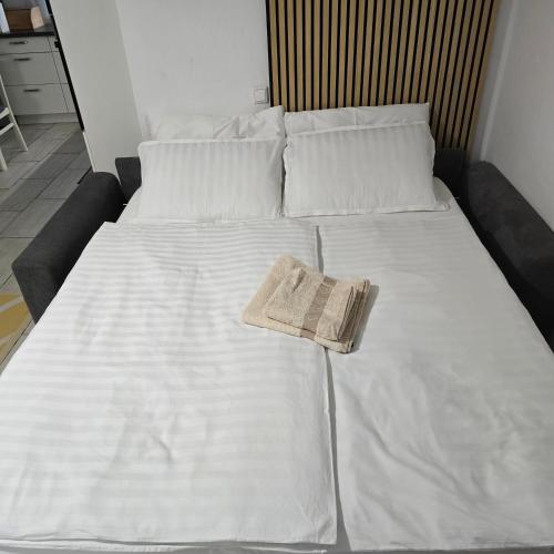 a large white bed with a book on it at Pri tetki 2 in Kranj
