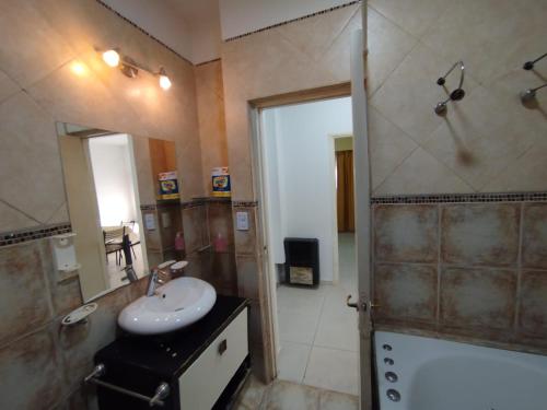 a bathroom with a sink and a shower with a mirror at Aprt Belgrano 658 in Neuquén