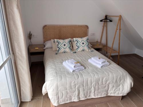 a bedroom with a bed with towels on it at Loft Jacuzzi Algarrobo in Arcos de la Frontera