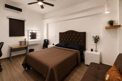 a bedroom with a large bed and a television at Alameda Suites & CAS - Centro Monterrey in Monterrey