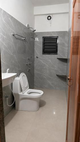 a bathroom with a toilet and a sink at KwaChen Stays in Panchanai