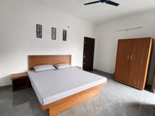 a bedroom with a large bed and a brown cabinet at KwaChen Stays in Panchanai