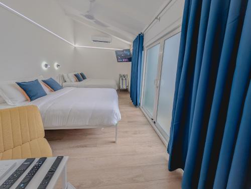 ein Schlafzimmer mit einem Bett, einer Couch und blauen Vorhängen in der Unterkunft T Loft in Playa Hermosa
