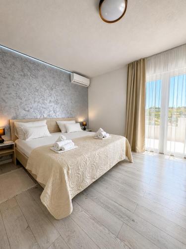 a bedroom with a large bed and a large window at Paulina Harmony Rooms in Seget Vranjica