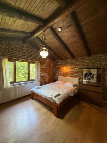 a bedroom with a large bed in a brick wall at Kybele Nature Life in Edremit