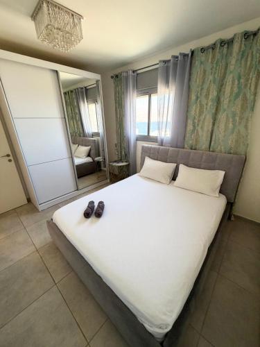 a bedroom with a large bed with shoes on it at Dream house in Eilat