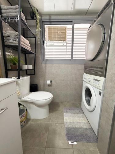 a bathroom with a toilet and a washing machine at Dream house in Eilat