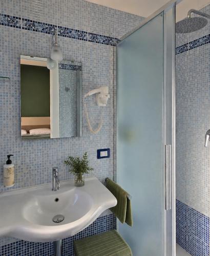 a bathroom with a sink and a shower at Hotel Residence Torre Del Porto in Mattinata