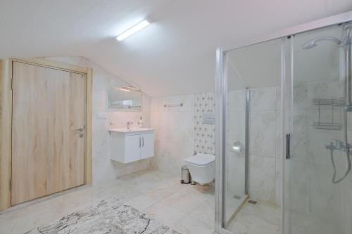 a bathroom with a shower and a toilet and a sink at villa hazar in Ortaca