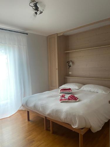 a bedroom with a bed with two towels on it at Casette Margherita in Fiera di Primiero