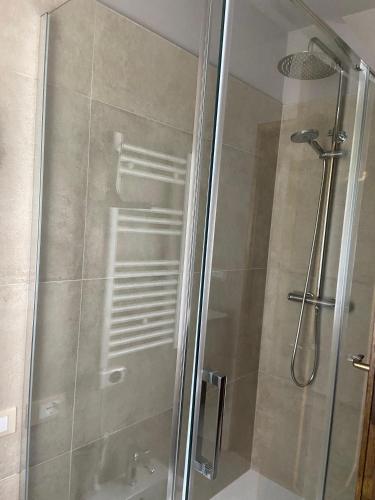 a shower with a glass door in a bathroom at Casette Margherita in Fiera di Primiero
