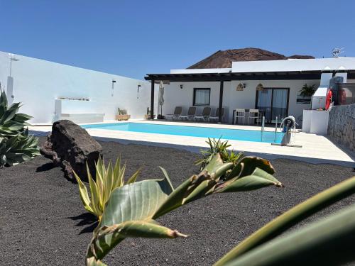 a house with a swimming pool in front of it at Villas Rodríguez in Playa Blanca