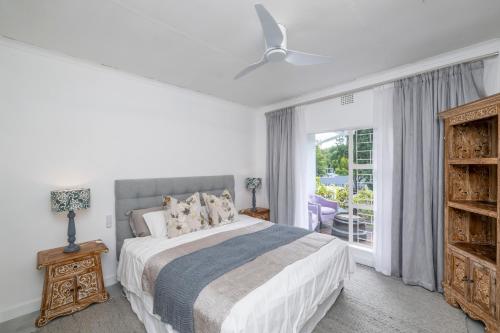 a white bedroom with a bed and a window at 8 Sleeper, 4 Bedroom Home in Franschhoek in Franschhoek