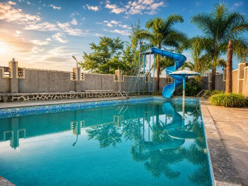 a blue swimming pool with a slide in the middle at Royal Heritage Lonavla - 7BHK with Turf in Lonavala