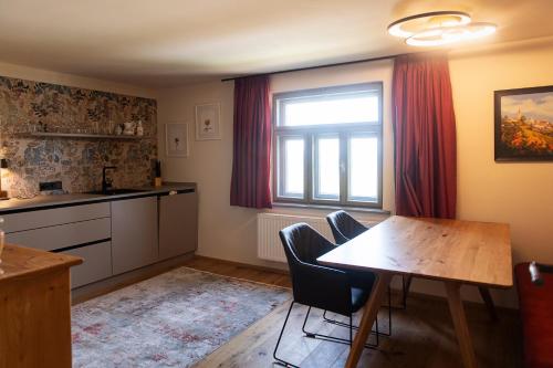 a kitchen and dining room with a table and a window at Kellerstöckl am Neusetzberg in Straden