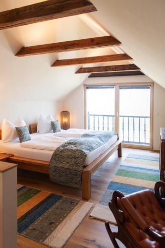 a bedroom with a large bed and a large window at Kellerstöckl am Neusetzberg in Straden