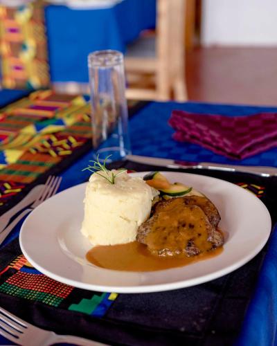a white plate with a piece of food on a table at Marera Eco Lodge in Karatu