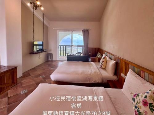 a bedroom with two beds and a window at Little Path Kenting in Eluan